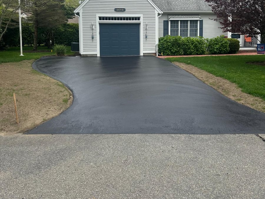 Smooth freshly sealed driveway leading to a garage
