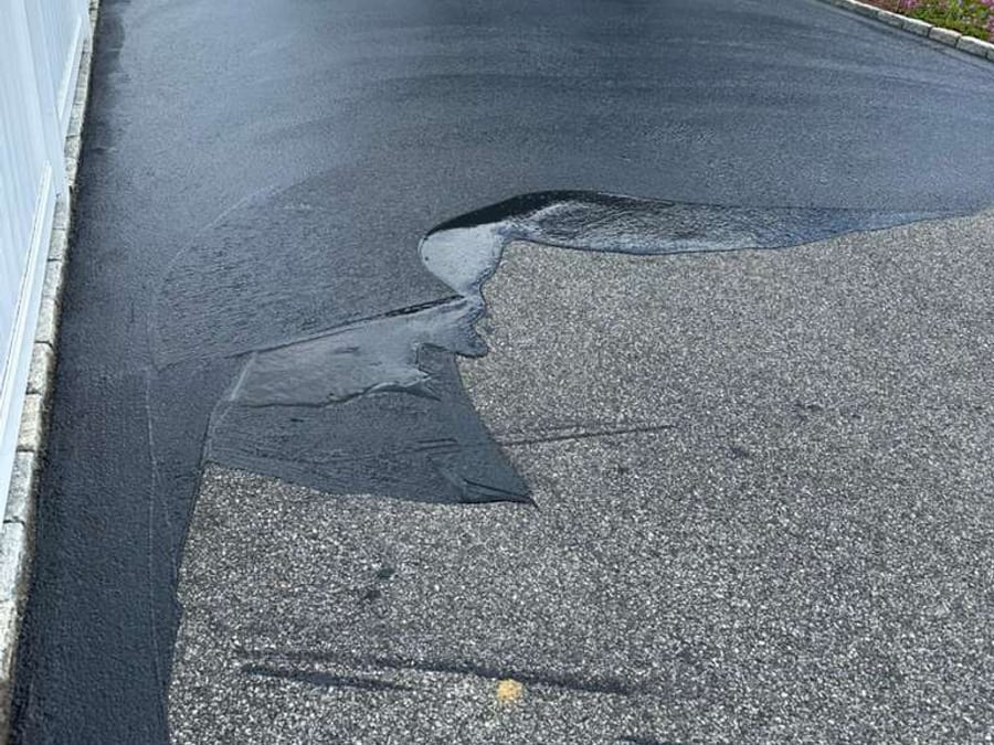 Sealcoat being applied across a residential driveway